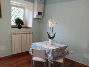 a dining room table with a vase of flowers on it at A due passi dal castello in San Pio delle Camere