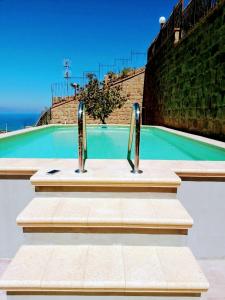 a swimming pool with two metal handles in front of it at Villa Verde in Cefalù
