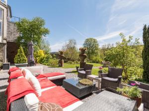 eine Terrasse mit einem Sofa und Stühlen im Hof in der Unterkunft Hotel Dufays in Stavelot