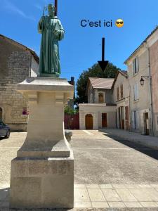 a statue of a man on a pedestal in a street at Appartement de l’abbaye in Saint-Astier