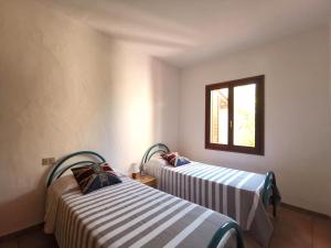two beds in a room with a window at Domenique in Budoni