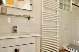 bagno bianco con lavandino e servizi igienici di Maisonnette au centre de Deauville a Deauville
