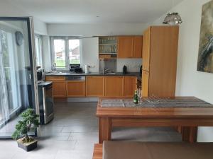 a large kitchen with wooden cabinets and a wooden table at Casa Bianka in Fridolfing