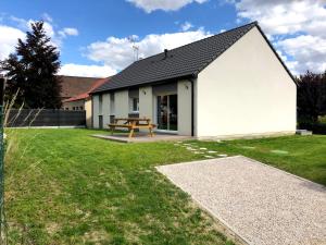 een wit huis met een picknicktafel in de tuin bij Aux Chants des Oiseaux in Ligny-Thilloy