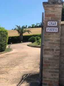 ein Schild an einer Backsteinmauer neben einer Auffahrt in der Unterkunft B&B Casa Fanny Riviera Del Conero in Loreto