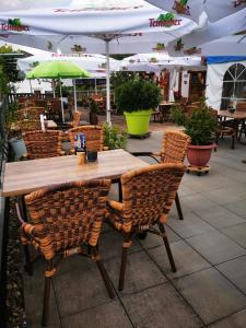 - une table en bois avec des chaises et des parasols sur la terrasse dans l'établissement Landhotel Engel, à Limbach