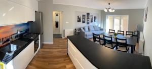 kuchnia i salon z kanapą i stołem w obiekcie Apartamenty Starowiejska w Gnieźnie