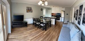 salon z kanapą i stołem oraz kuchnia w obiekcie Apartamenty Starowiejska w Gnieźnie