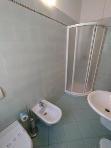ein Bad mit einer Dusche, einem WC und einem Waschbecken in der Unterkunft Albergo Ristorante Orazio in Sale Marasino