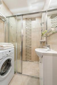 een badkamer met een wasmachine en een wastafel bij P&O Apartments Kasprzaka in Warschau