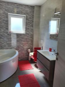 La salle de bains est pourvue d'une baignoire, d'un lavabo et de toilettes. dans l'établissement Apartment CReO Loborika, à Marčana