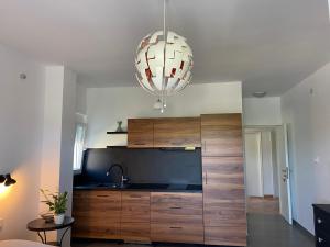 a kitchen with a large wooden cabinet and a chandelier at Casa Fumica Studio in Kampor