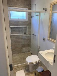 a bathroom with a toilet a sink and a shower at Pousada Conca di Mare - Restaurante - Pé na areia com serviço de praia in Bertioga