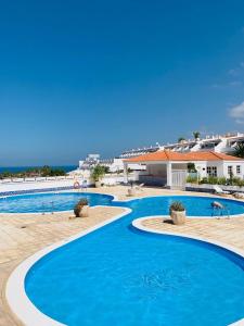 a swimming pool with blue water in a resort at BuenaVista Romantic Bungalow in Costa Adeje in Adeje