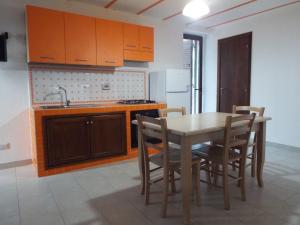 a kitchen with a table and chairs and a sink at ANFORA Arancione in Canneto