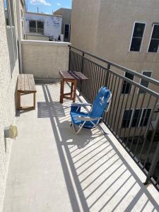 uma cadeira azul e uma mesa numa varanda em Cozy bedrooms at University City in Philadelphia em Filadélfia