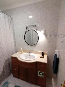 a bathroom with a sink and a mirror at Arquinha Apartment in Ponta Delgada