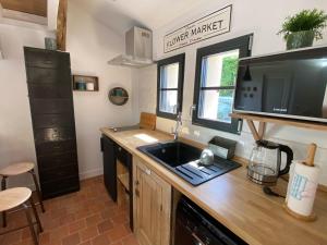 a kitchen with a sink and a television on a counter at Une Maison en Touraine in Saint-Branchs