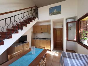 une cuisine et une salle à manger avec un escalier en colimaçon dans l'établissement Domenique, à Budoni