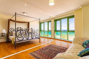 Habitación con cama, sofá y ventanas. en Arrecife Sands, en Arrecife