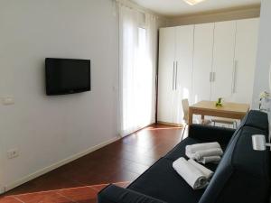 a living room with a couch and a television on a wall at Margherita Rimini - Appartamenti al Mare in Rimini