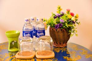 a table with bottles of water and a vase of flowers at Nohana Hotel in Mui Ne
