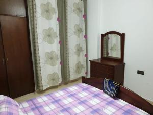 um quarto com uma cama, uma cómoda e um espelho em Résidence EL AMAL em Martil