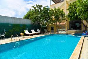 a swimming pool next to a building at Nohana Hotel in Mui Ne