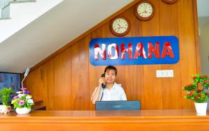 a woman talking on a phone in a nomite sign at Nohana Hotel in Mui Ne +21 photos