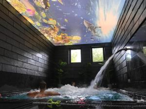dwie osoby w basenie z dużym akwarium w obiekcie Dom Wczasowy Klif & Spa we Władysławowie