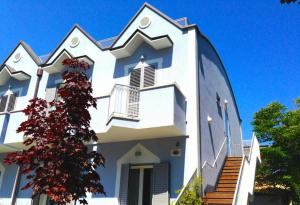 a large white building with stairs in front of it at Margherita Rimini - Appartamenti al Mare in Rimini