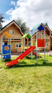 a group of playground equipment in front of a house at Janosik II in Ustronie Morskie