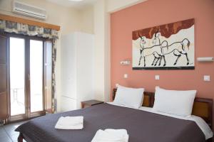 1 dormitorio con 1 cama y una pintura de un caballo en la pared en Villa Stella, en Fira