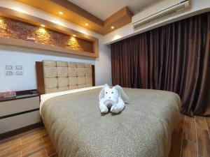 a teddy bear sitting on a bed in a bedroom at Garden Season Hotel in Cairo