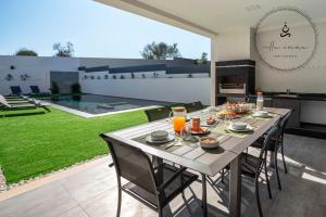 a dining room with a table and chairs in a backyard at V5 Villa Emma - Luxury 5 bedroom villa in Alvor with private Pool and Jacuzzi in Alvor
