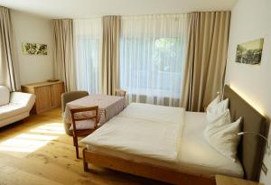 ein Schlafzimmer mit einem Bett, einem Sofa und einem Fenster in der Unterkunft Burgunderhof in Montan