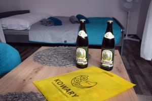 - deux bouteilles de bière assises sur une table dans une chambre dans l'établissement Apartament Górnicza w Kowarach, à Kowary