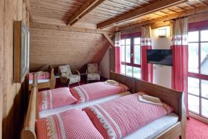 2 Betten in einem Zimmer mit Holzwänden und Fenstern in der Unterkunft Chalupa Andrea in Abertamy
