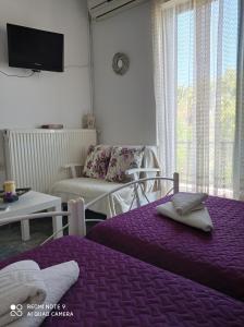 un soggiorno con 2 letti e un divano di Nancy Rooms a Skala Kallonis