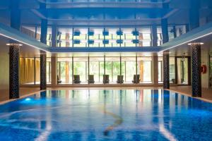 a large swimming pool in a large room with windows at Sopotorium Hotel & Medical Spa in Sopot