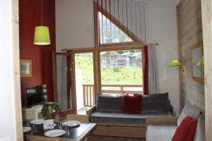 a living room with a couch and a large window at Résidence Christiana 408 Clés Blanches Courchevel in Courchevel