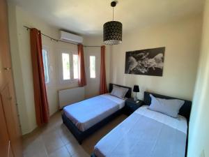2 camas en una habitación con 2 ventanas en Ivy house modern life near Corfu town en Kontokali
