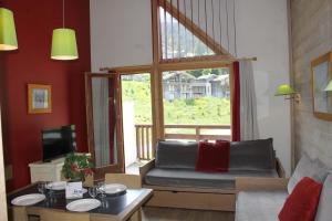 a living room with a couch and a large window at Résidence Christiana 408 Clés Blanches Courchevel in Courchevel