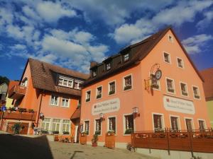 ein orangefarbenes Gebäude mit braunem Dach in der Unterkunft Hotel Wilder Mann in Feuchtwangen