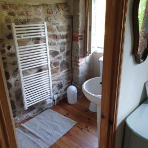 baño con lavabo y aseo y ventana en Gîte de la Founauderie, en Roncey