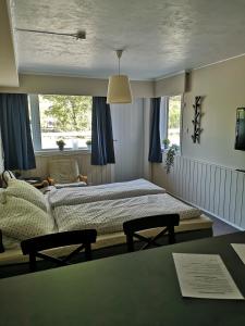 a bedroom with a bed with blue curtains and a table at Kvamsdal Pensjonat 4 in Eidfjord