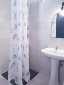 a white bathroom with a sink and a shower curtain at Konstantinos-Elli Rooms in Nea Vrasna