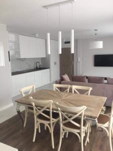 kuchnia i jadalnia z drewnianym stołem i krzesłami w obiekcie Apartament Amalia z tarasem widokowym i bocznym balkonem w Rewalu