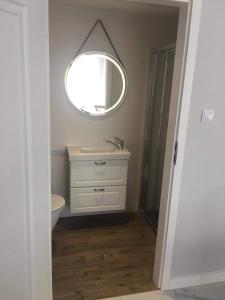 La salle de bains est pourvue d'un lavabo blanc et d'un miroir. dans l'établissement Apartament Amalia z tarasem widokowym i bocznym balkonem, à Rewal