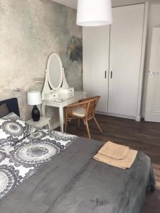 sypialnia z łóżkiem i biurkiem z lustrem w obiekcie Apartament Amalia z tarasem widokowym i bocznym balkonem w Rewalu